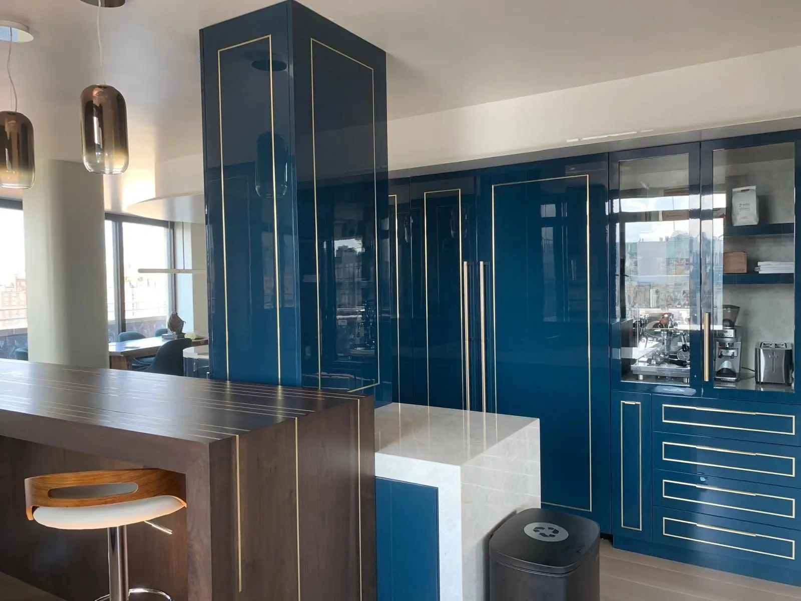 High-gloss blue lacquer kitchen cabinetry with metal inlay detailing