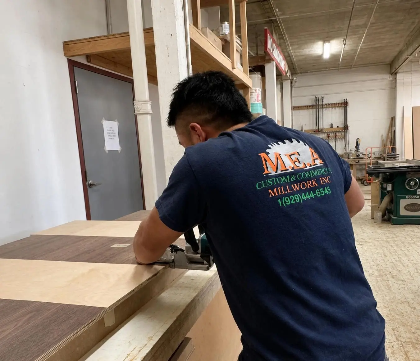Carpenter working on a veneered panel in the M.E.A. shop